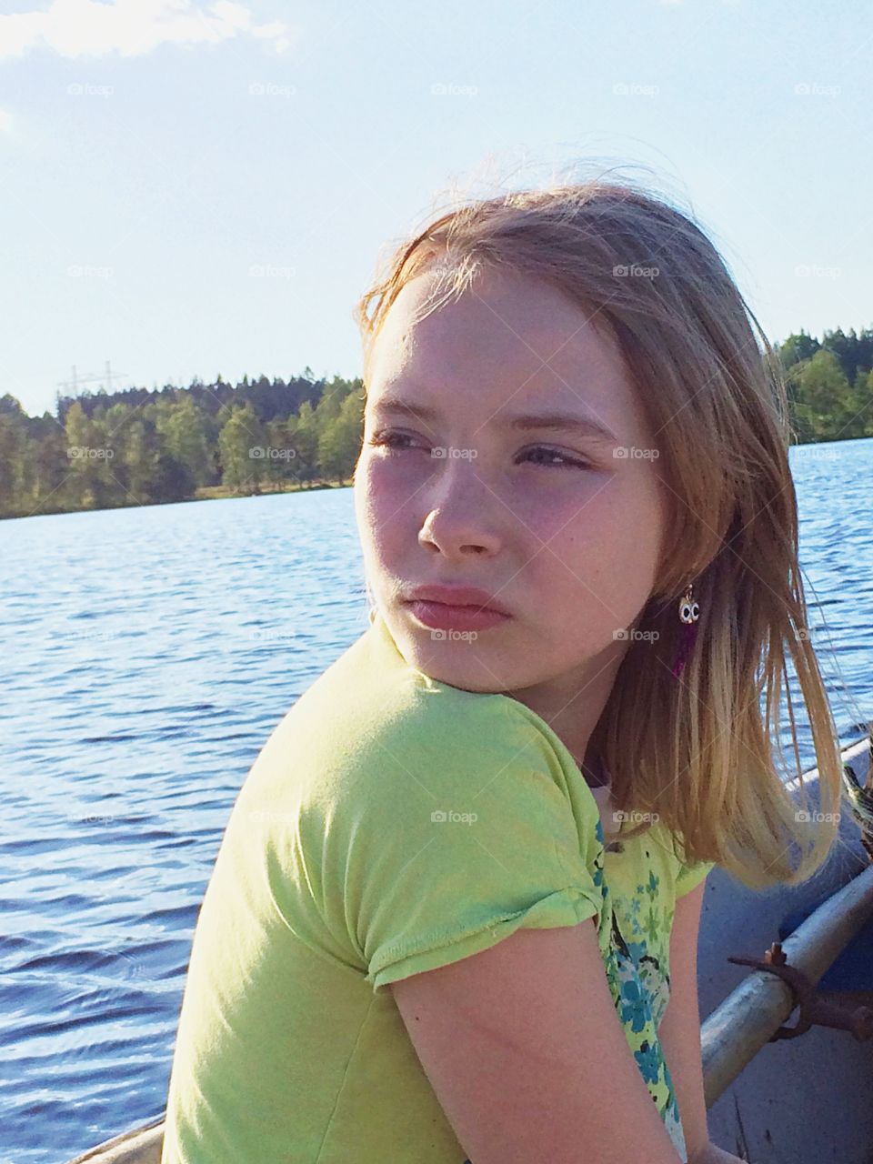 Go by boat. A girl sitting in the boat and enjoys the wind