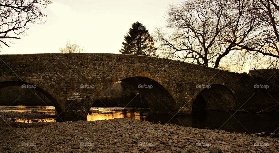 The setting of a winter sun caught in the shallow water of the River Exe at Exebridge