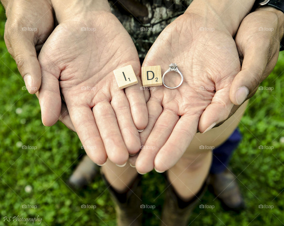 Couple holding ring and text i do on blocks in hands