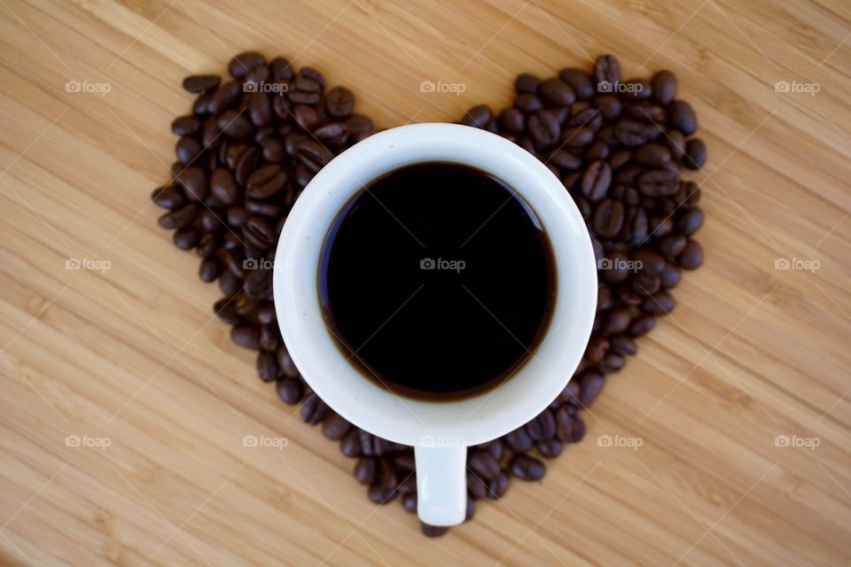 Black coffee with beans in heart shape
