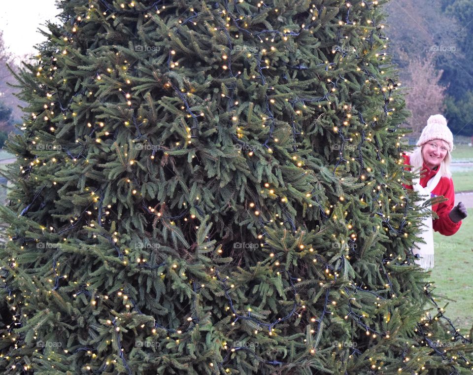 Lit up christmas tree with woman in background