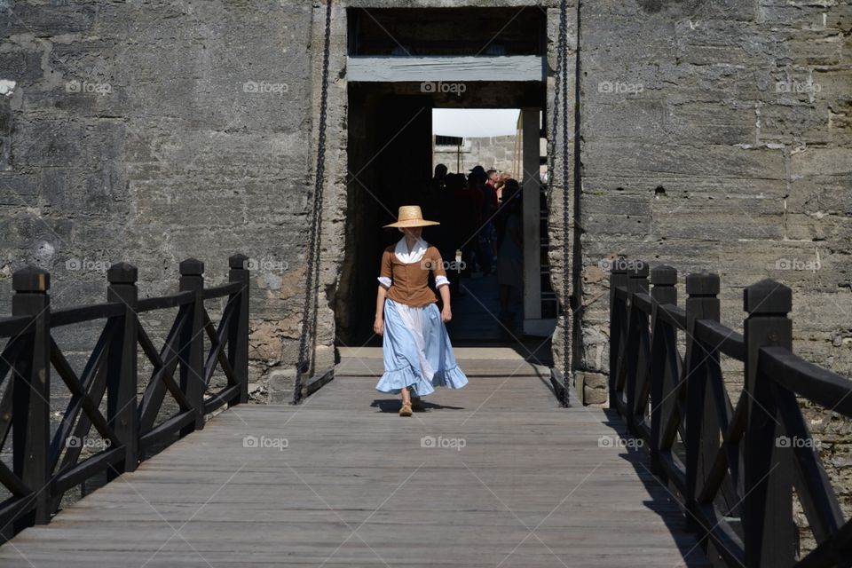 Revolutionary War reenactment character walks across the Fort's bridge.
