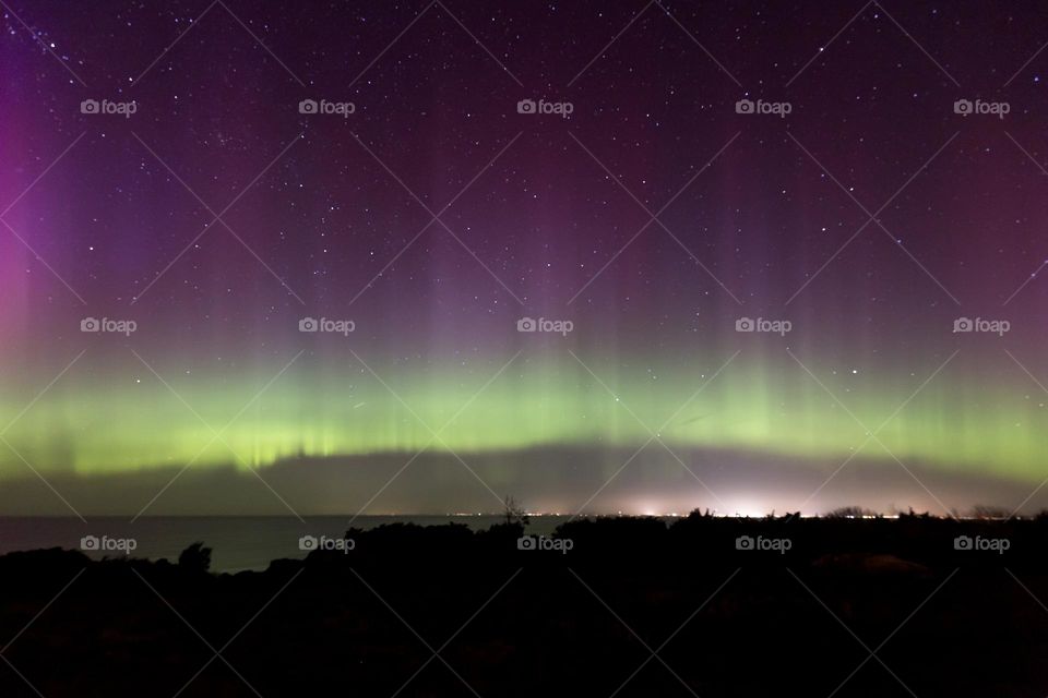 Strong colorful northern light above the ocean in Sweden 