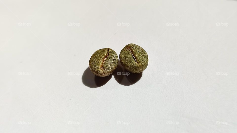 macro image of golden colour Coffee beans on a white surface