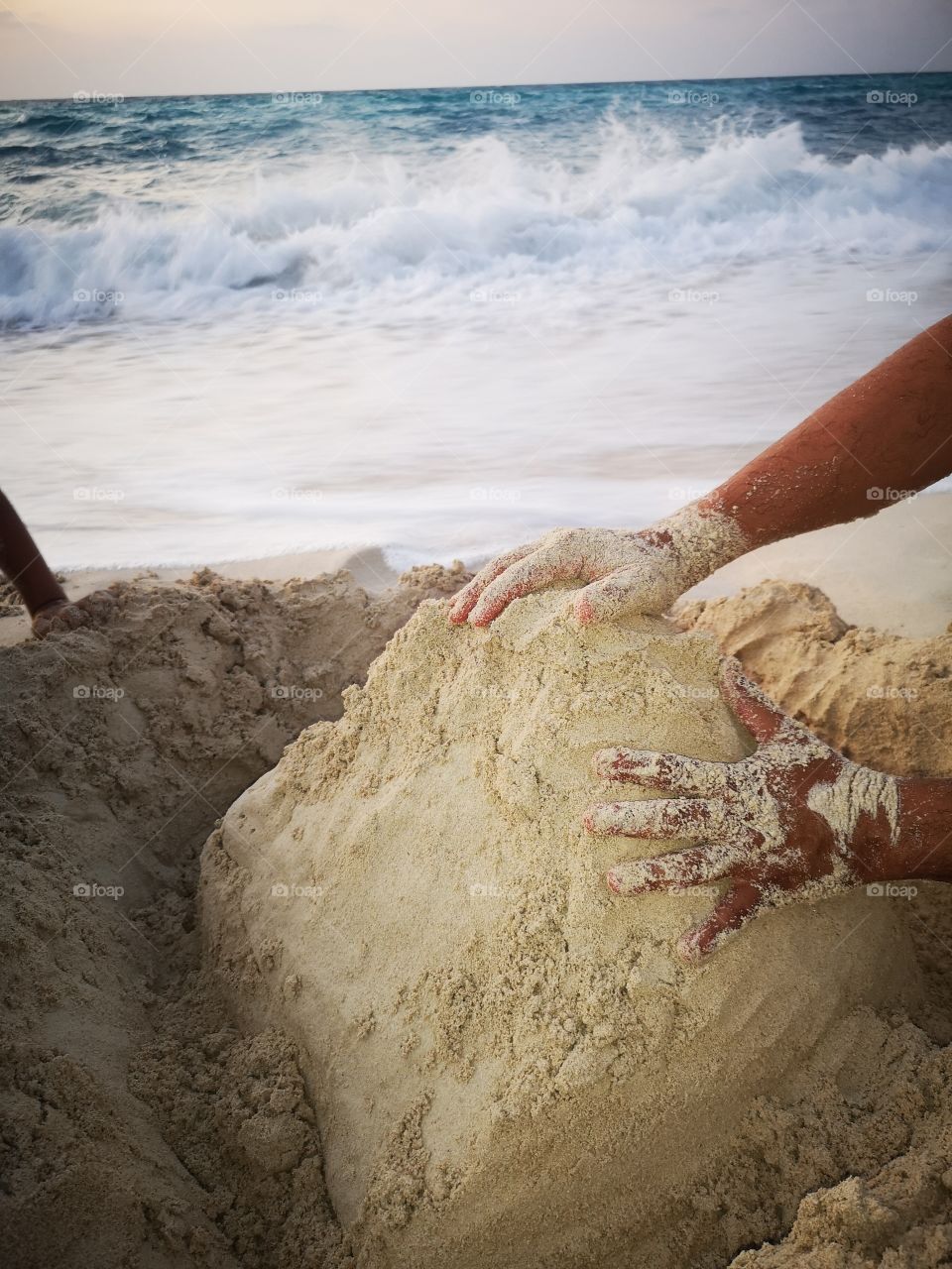 Me and my family love making a mountain peak by using beach sand, then we wait the sea waves to come around it. It's a wonderful sight!