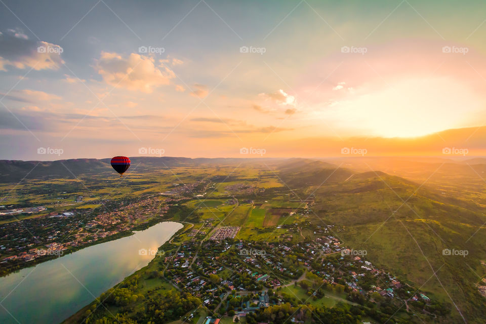 Let's fly - image of hot air balloon at sunrise with river and valley below