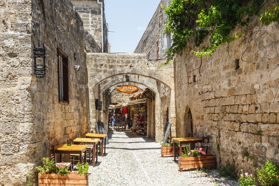 Street view of old town Rhodes. Street view of old town Rhodes, restaurants and souvenir shops by old street brick wall, Rhodes island, Mediterranean 