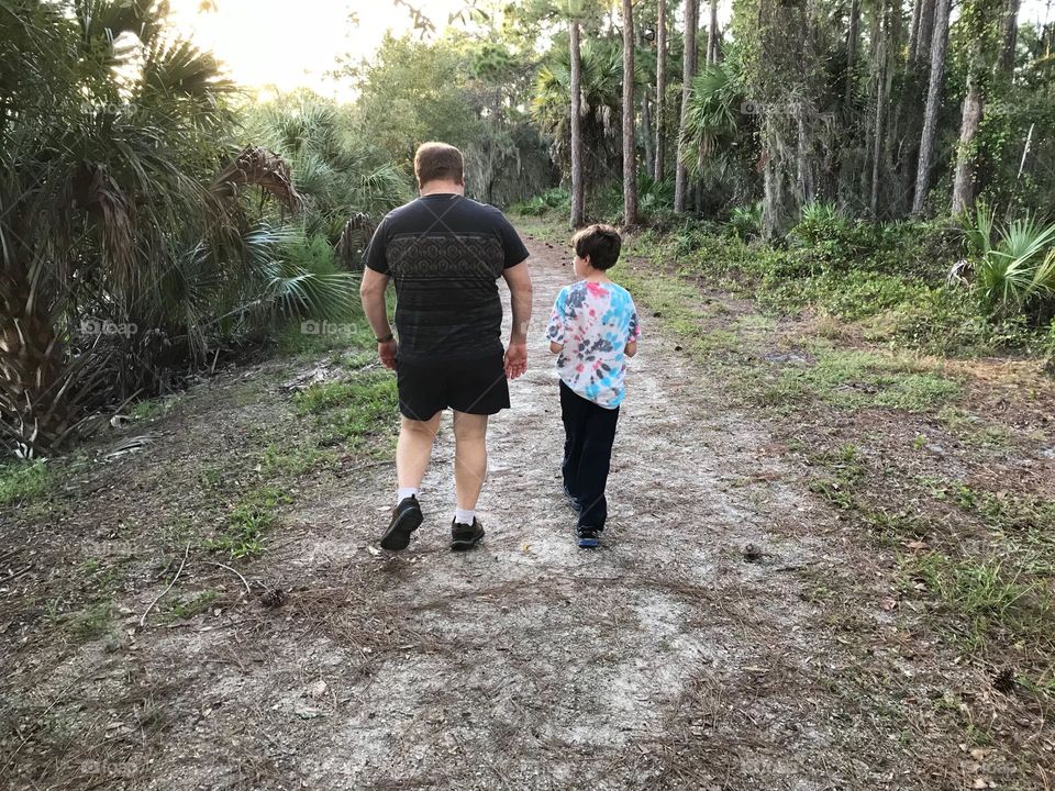 Father and son walking through the woods.