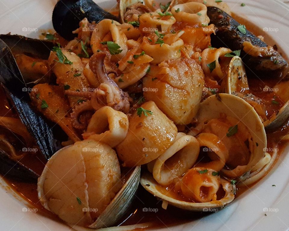 Seafood delight. one of my favorite meals, zuppa di pesce with mouthwatering scallops, muscles, shrimp, in a marinara sauce over linguini