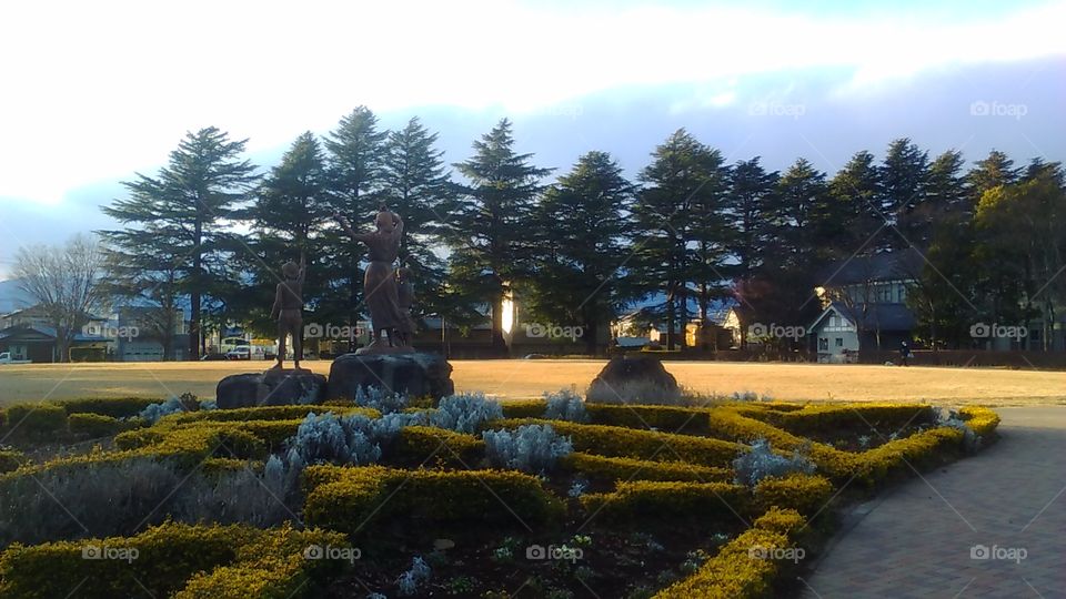 A gentle sunset illiminates the shrubs, sculpures, and lawns of Agata No Mori Park in Matsumoto.