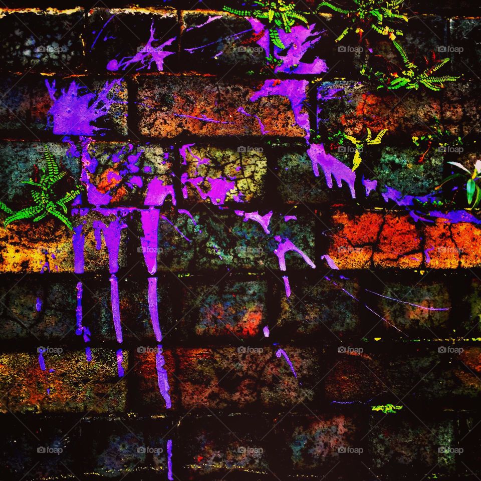 Bright purple paint splattered on a brick wall, colorful purple paint on a brick wall, paint splatters in England 