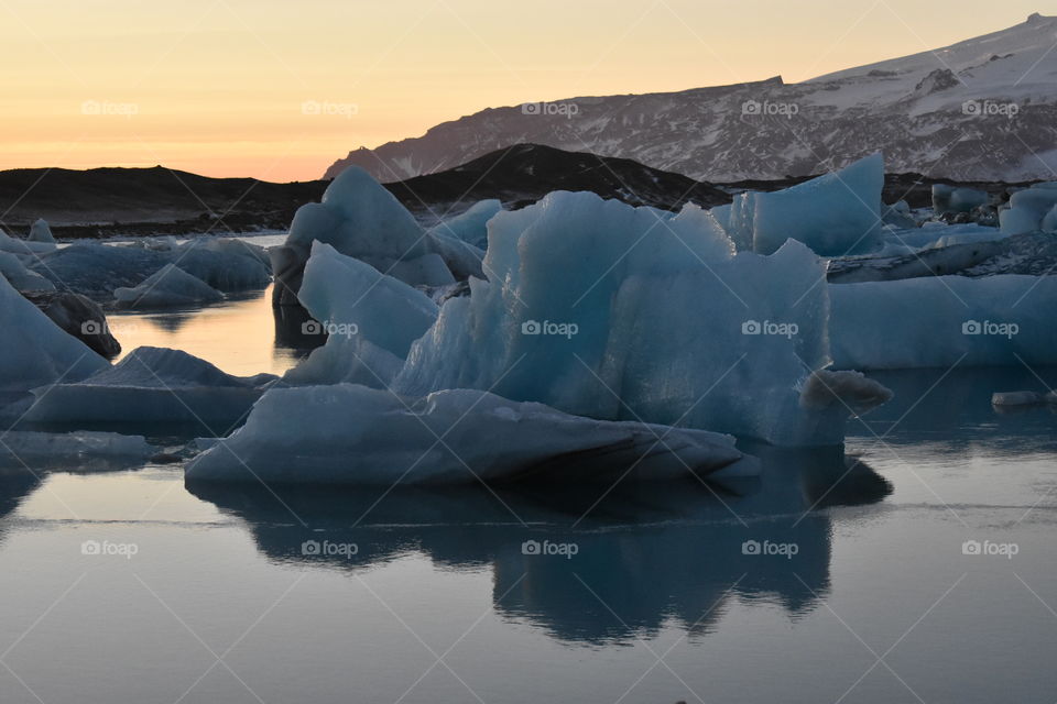 Iceberg reflecting peacefully at sunset