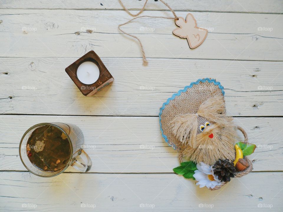 cup of tea, crafts, candle and an angel on the table