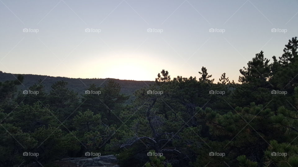 The sun breaking over Acadia National Park in the late summer.