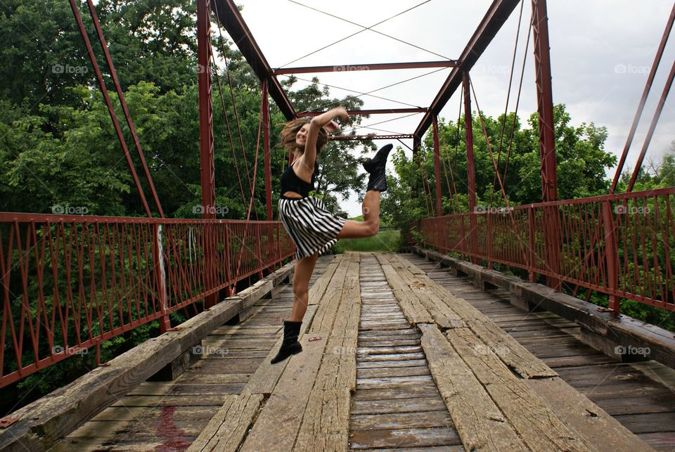 Leap. Teen girl dancing on a bridge 
