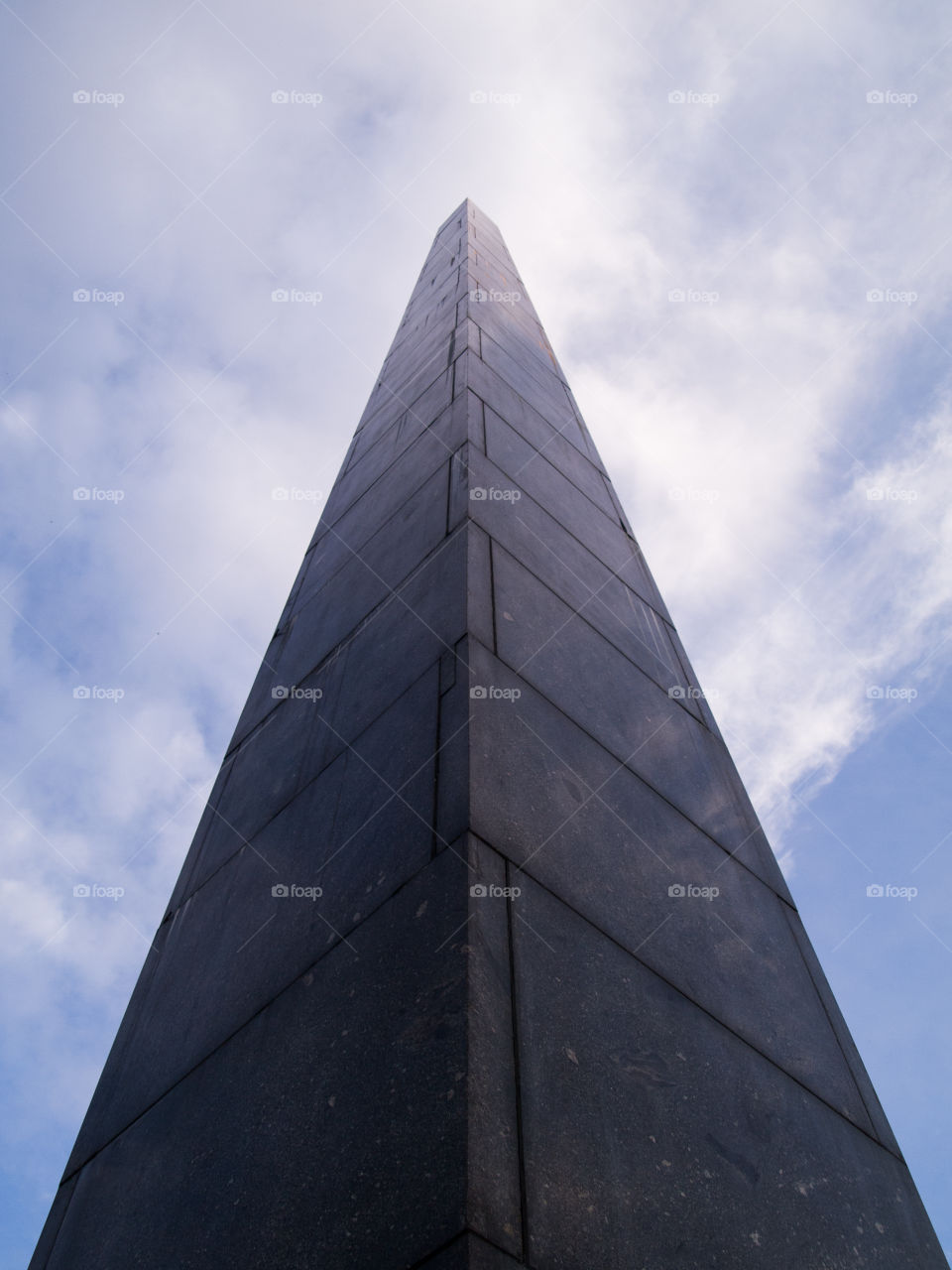 gray concrete cone-shaped monument under a blue sky with white clouds 2
