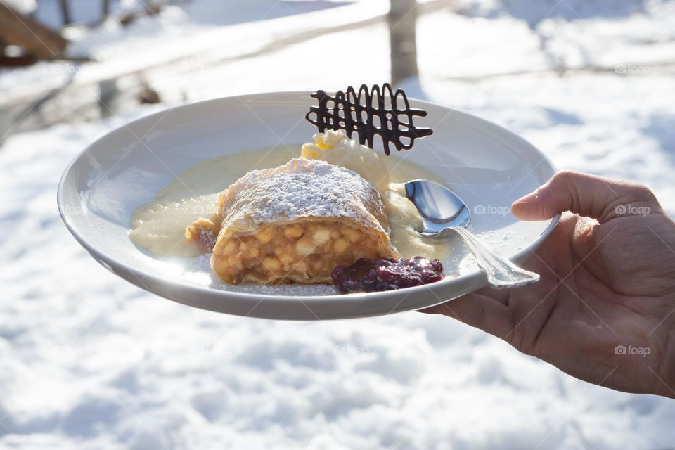 apple strudel on a plate, snow in the background