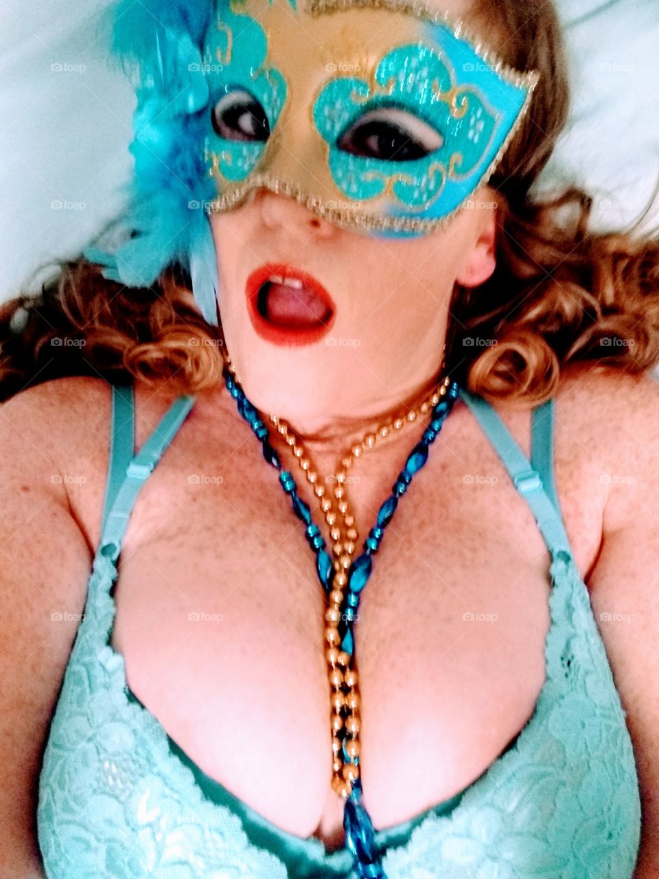 Red head woman with mardi gras mask.