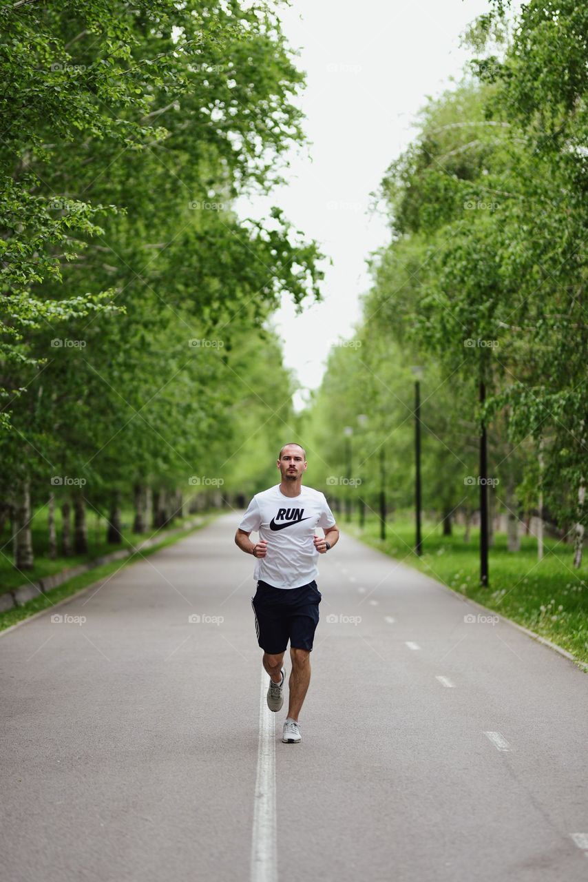 Man running through a park lane