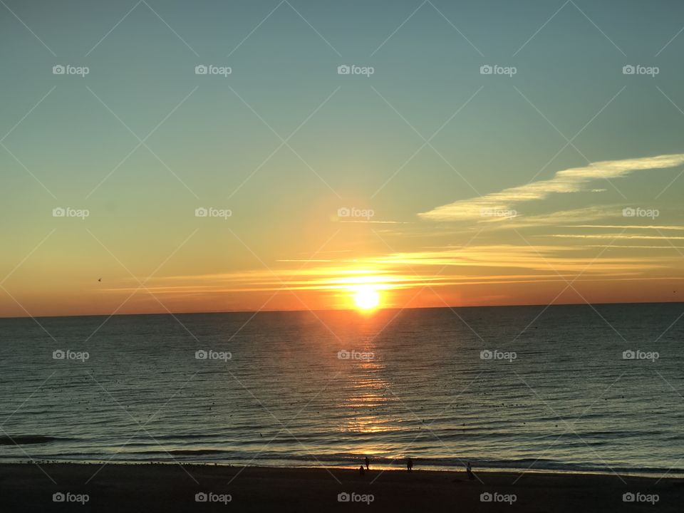 The beautiful sun rise . Early in the morning look outside, the beautiful sun in the sky. The line of the sea connected to the horizon .