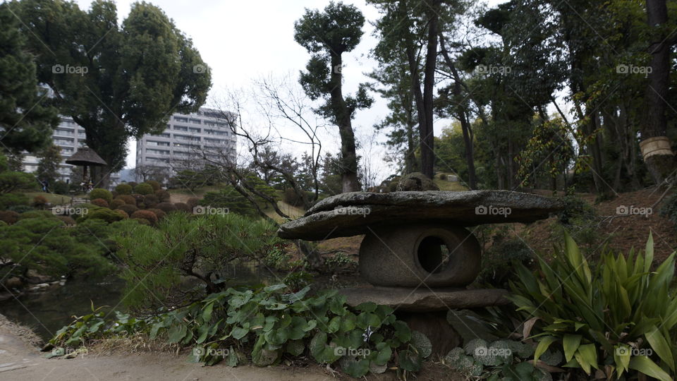 Natural looking stone lantern in a traditional Japanese garden in Hiroshima, Japan