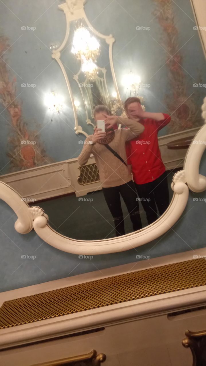 Two man standing in front of mirror