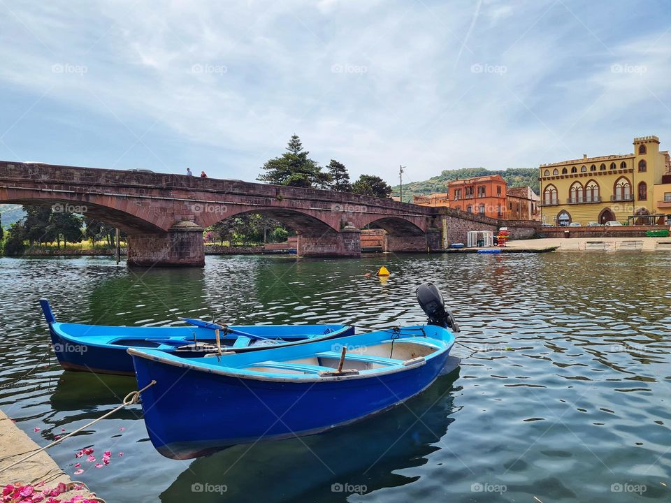 blue gondolas on the Temo river in Bosa (Sardinia)