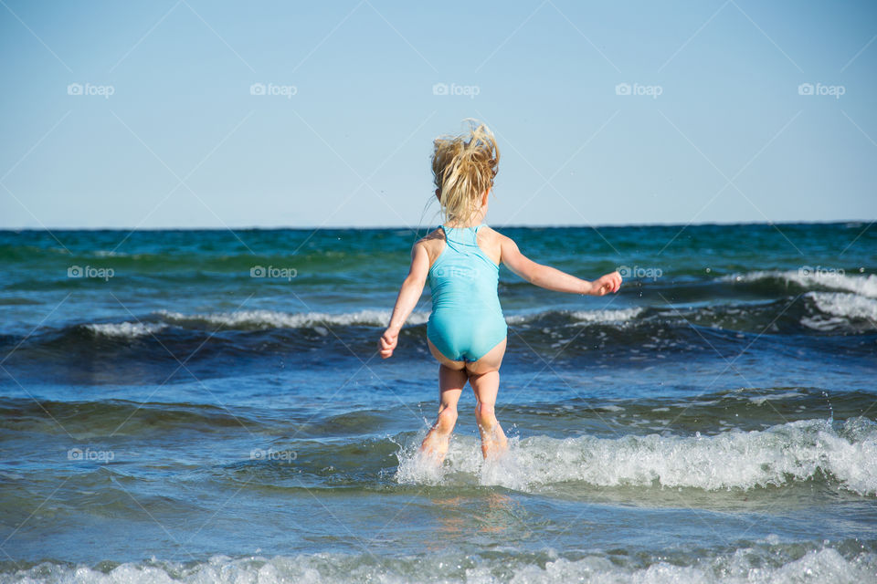 Two young sisters age five and three playing on the beach in Höllviken in Sweden.