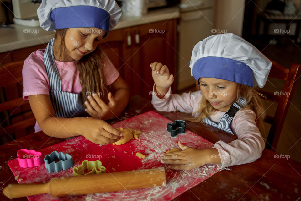 Little sisters cooking the biscuits 