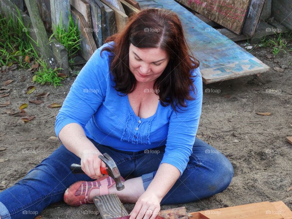 Woman Hard At Work As A Carpenter. Hammer And Nails
