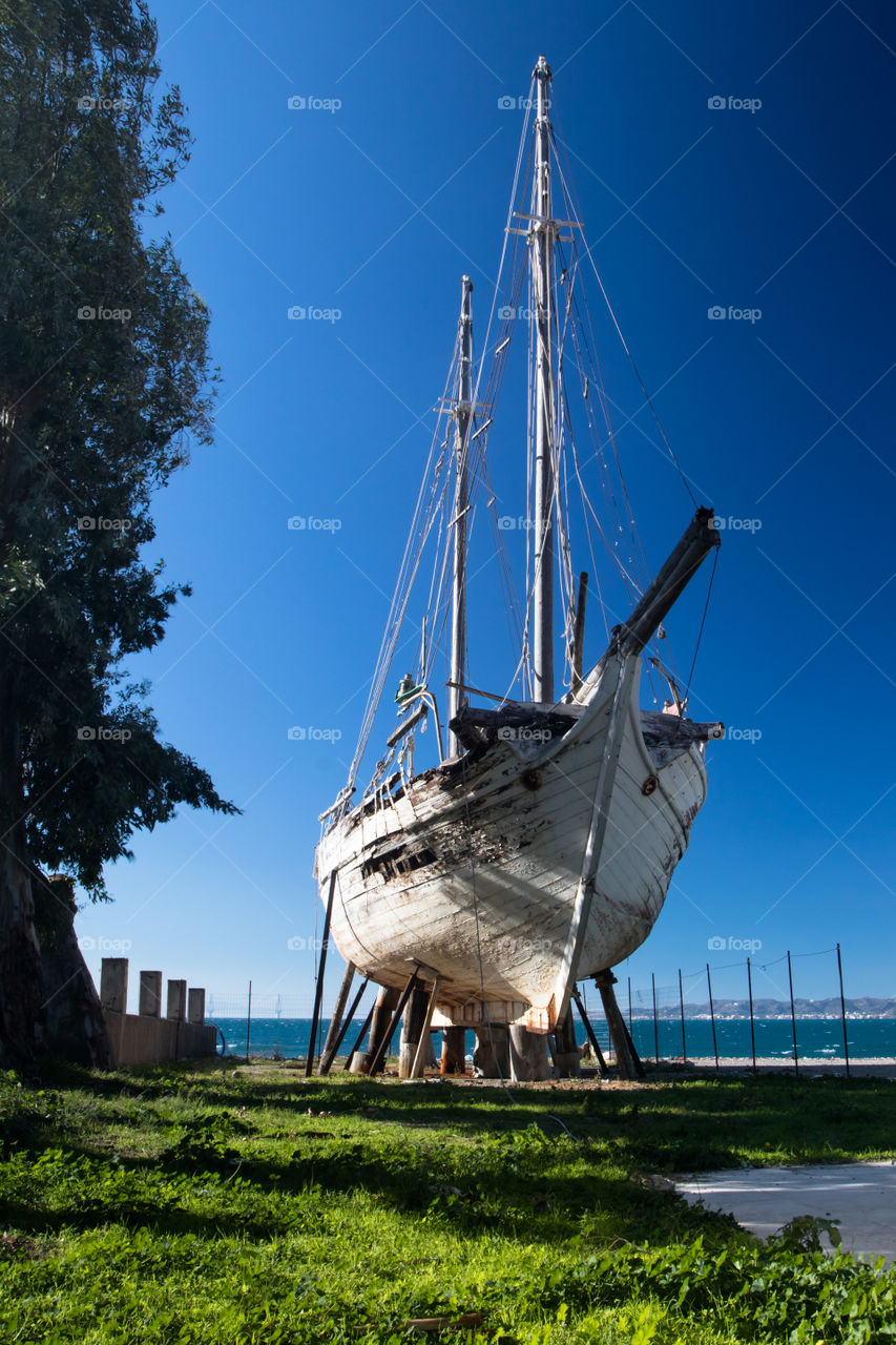 old wooden sailboot in front of the sea