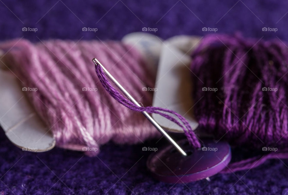 Needle and purple threads on purple polard