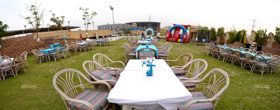 chairs and tables with center piece and decoratiob ready for a party