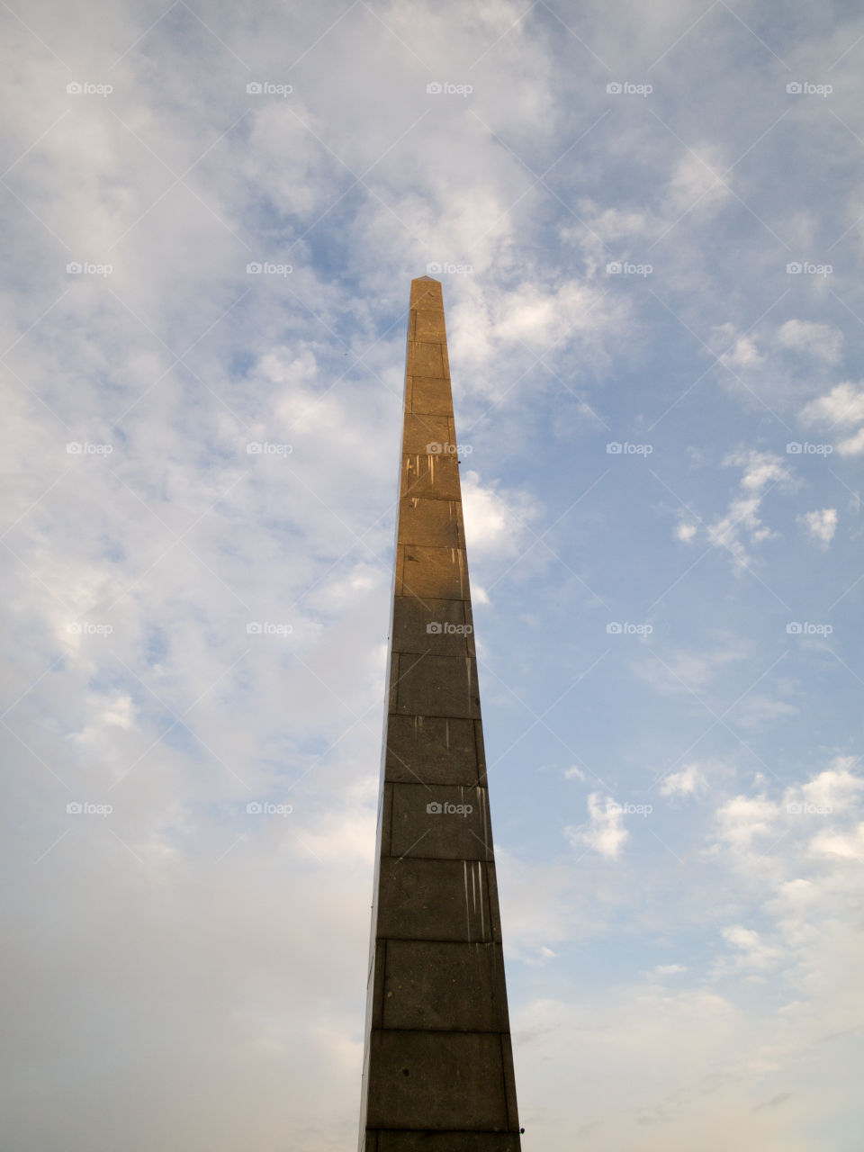 gray concrete cone-shaped monument under a blue sky with white clouds 5