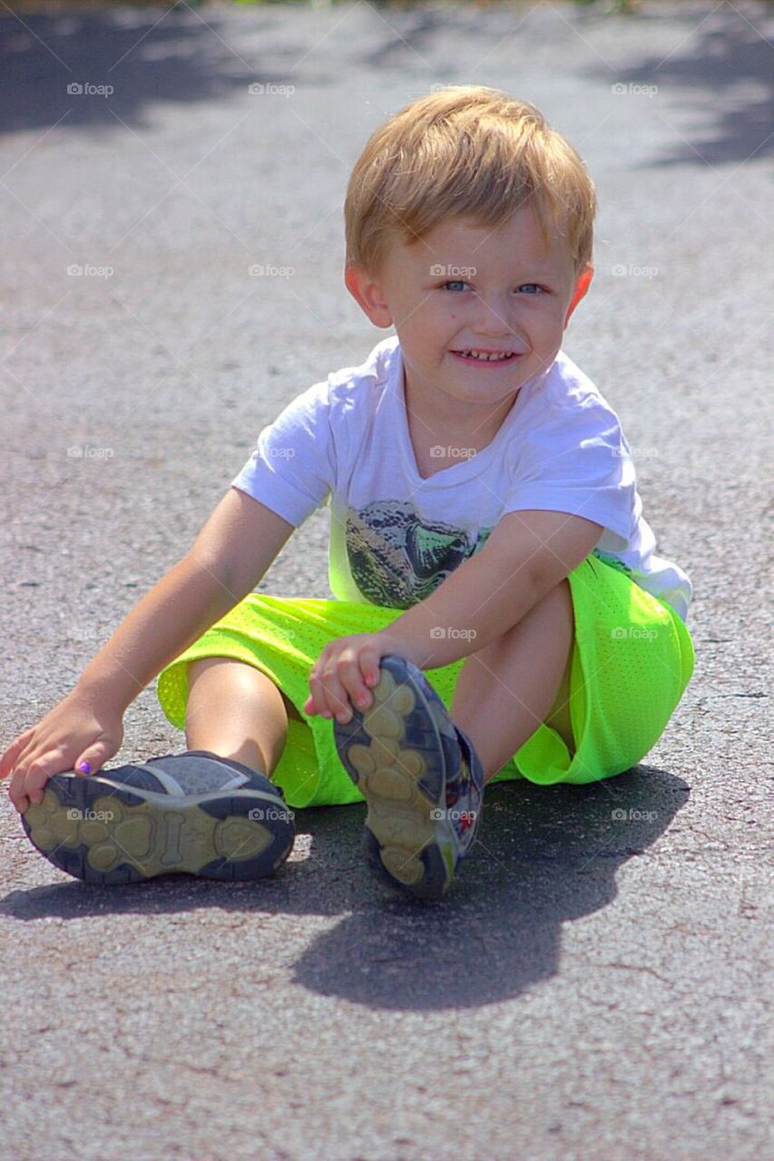 Smiling boy sitting on street