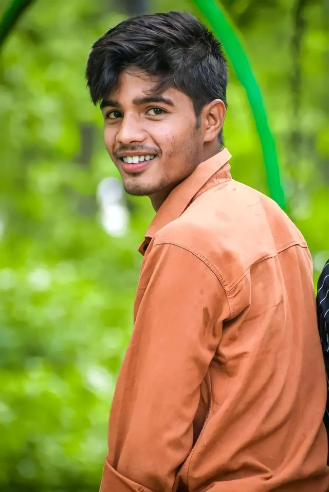a boy looking camera with smiley face and black silky hair
