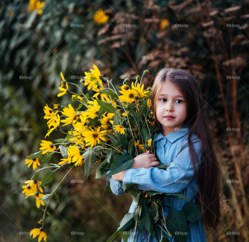 A portrait of a girl with yellow  flowers