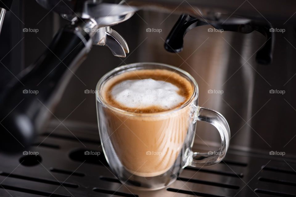Closeup shot of an espresso coffee drink with foam on an espresso machine 