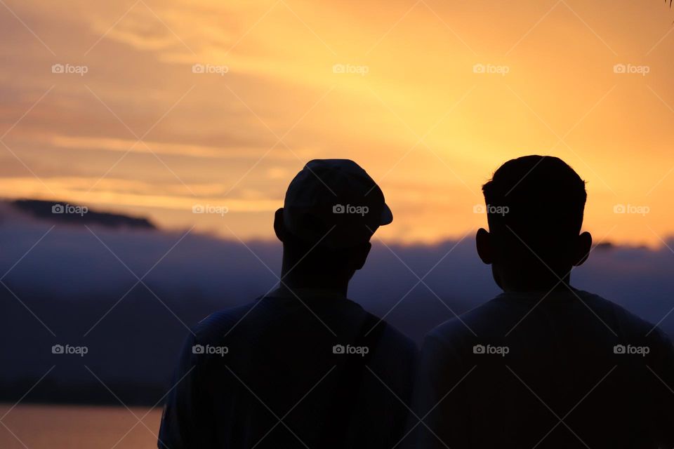 People viewing the golden sunset with beautiful scenery by the lake