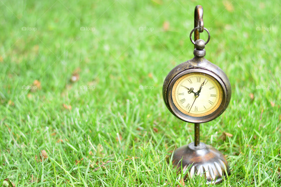 clock outside on the grass