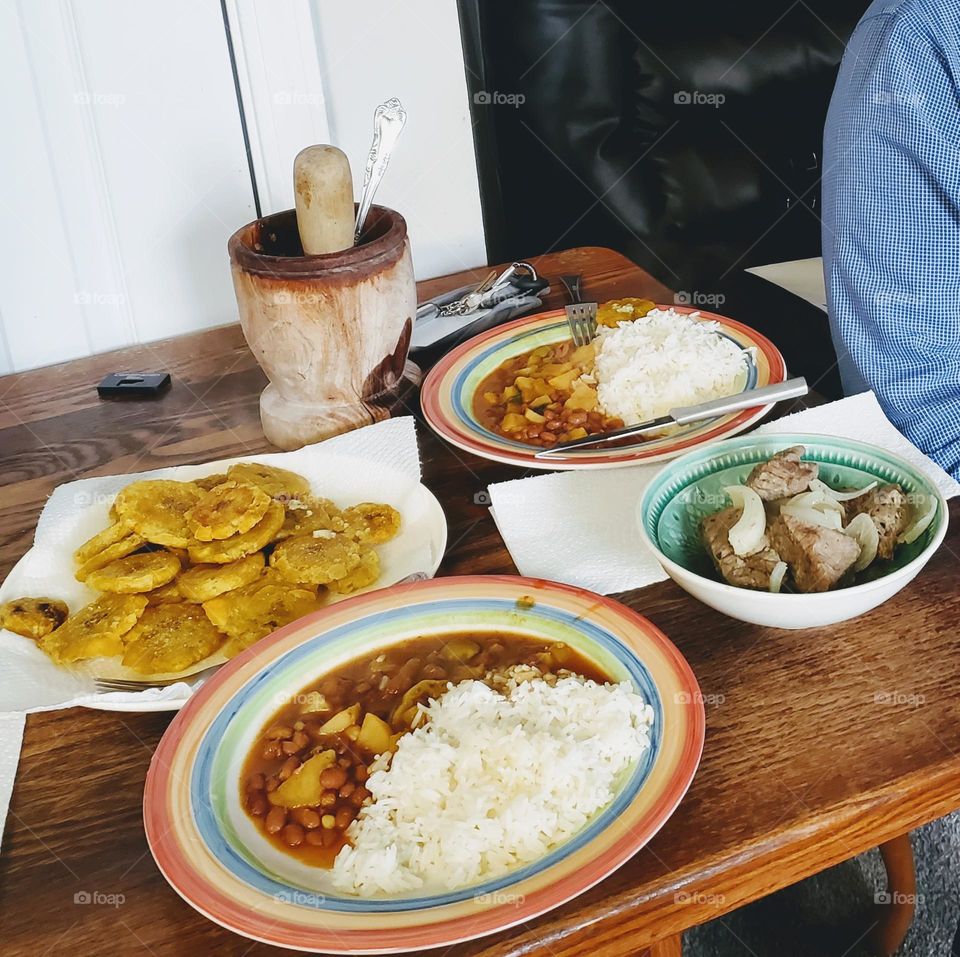 arroz Jasmin blanco, habichuelas rosadas guisadas  tostones y biftec encebollado. (white Jasmin rice, stewed pink beans, fried green plaintains, beefsteak with onions)