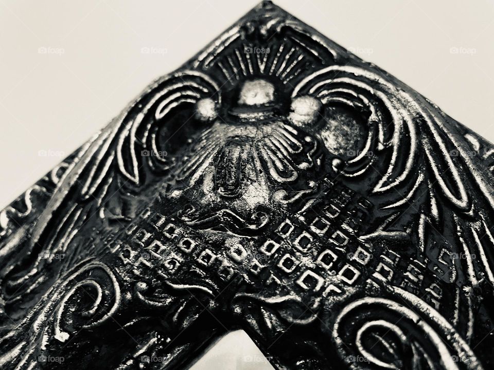 Decorative ornamentation on a mirror frame in black and white. Detailed and textured image