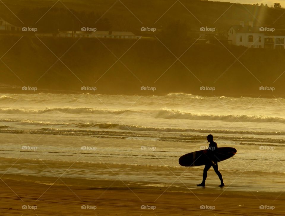Surfer returning from the waves on Irelands west coast