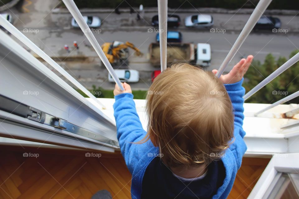 A boy looks out the window at the road works