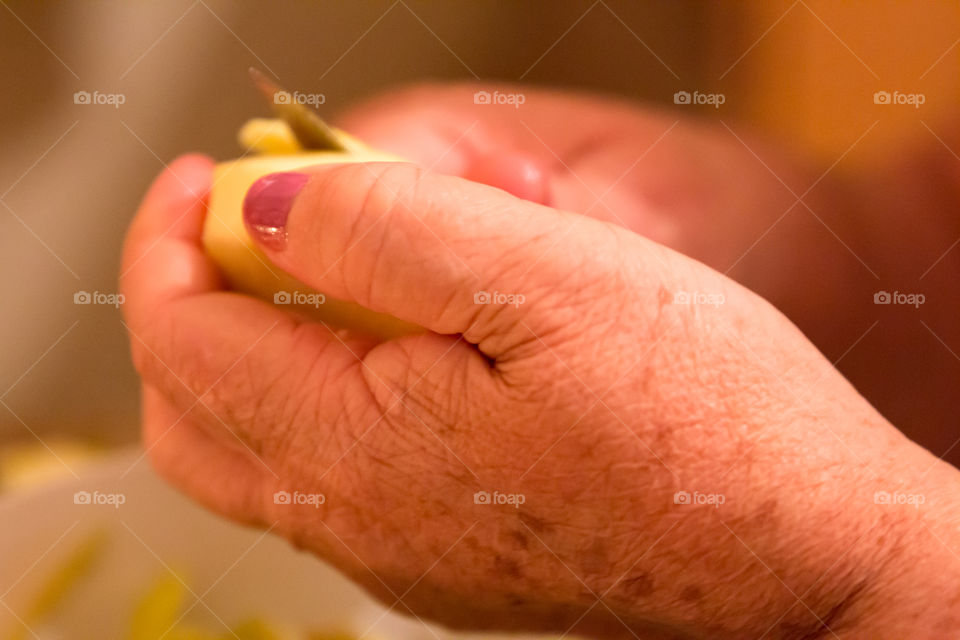 Woman's Aging Hands Peeling A Green Apple
