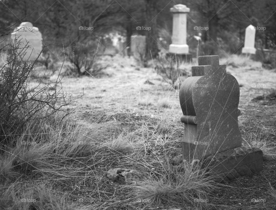 A spooky old Pioneer Graveyard with leaning headstones in the rural woods and hills of Central Oregon. 
