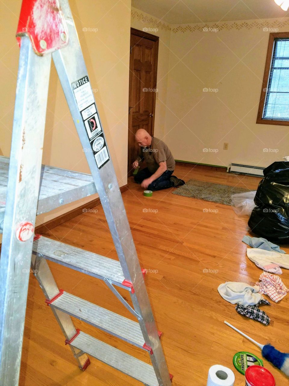 #stayathome - DIY home projects. Ladder and supplies in room for painting. Painter tapes off wood trim.