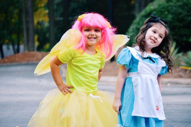 Cute girl in fairy wing standing with her friend