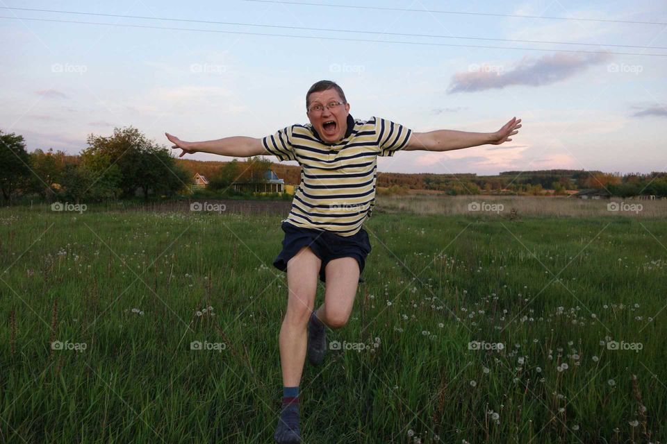 Man running and jumping on meadow
