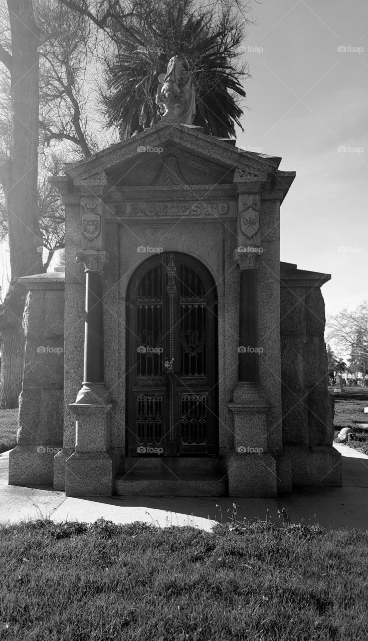 a large family crypt long since last used. the top has half of what looks like it was a greek godess with an urn. unknown how or when it broke off.